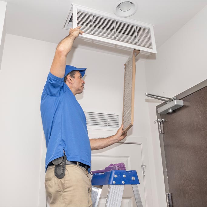 person replacing an hvac vent filter